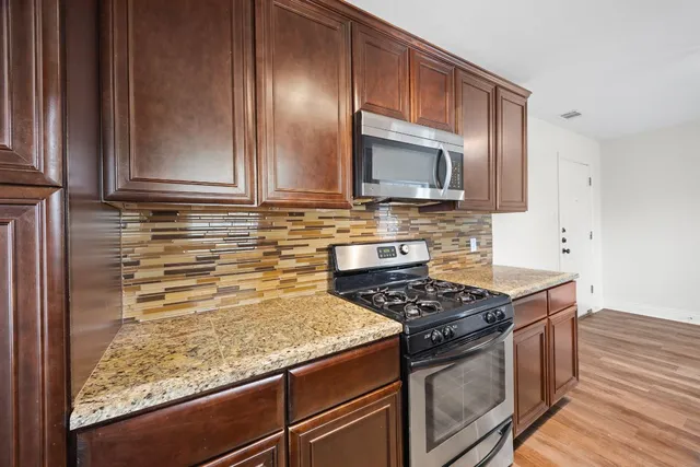 a kitchen with wooden cabinets and a stove top oven