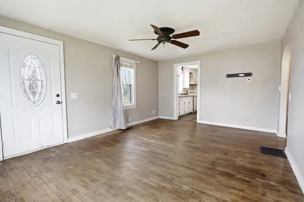 a view of empty room with wooden floor and window