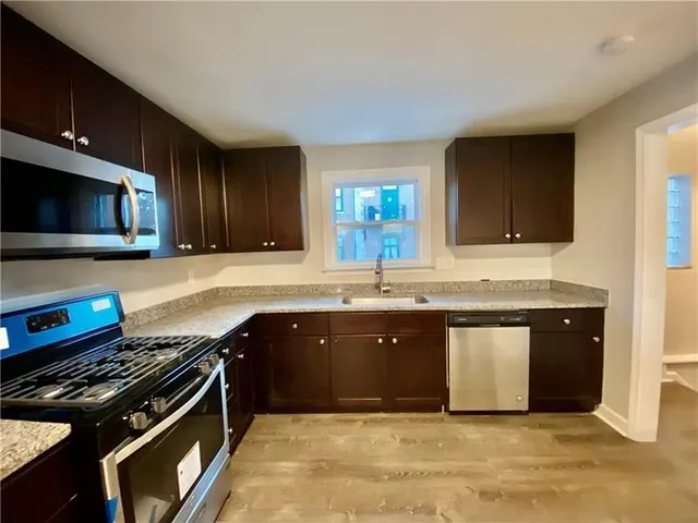 a kitchen with granite countertop a stove and a sink
