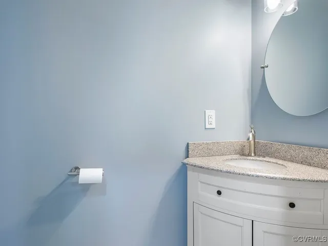 a bathroom with a granite countertop sink and mirror