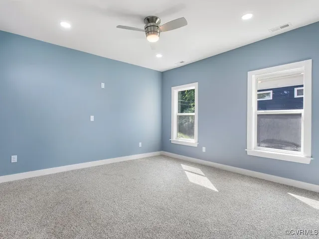 an empty room with a window and a ceiling fan