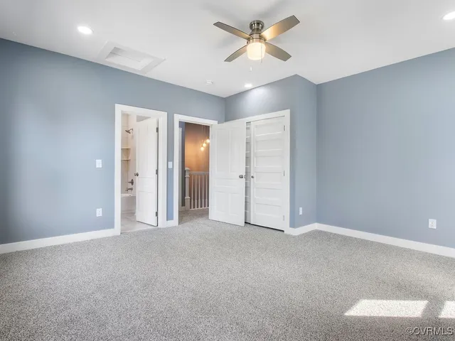 an empty room with closet and a ceiling fan