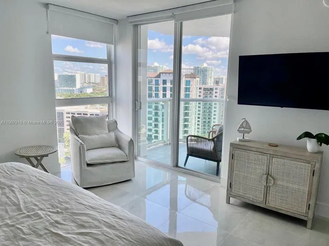 a bed room with a bed and a flat tv screen