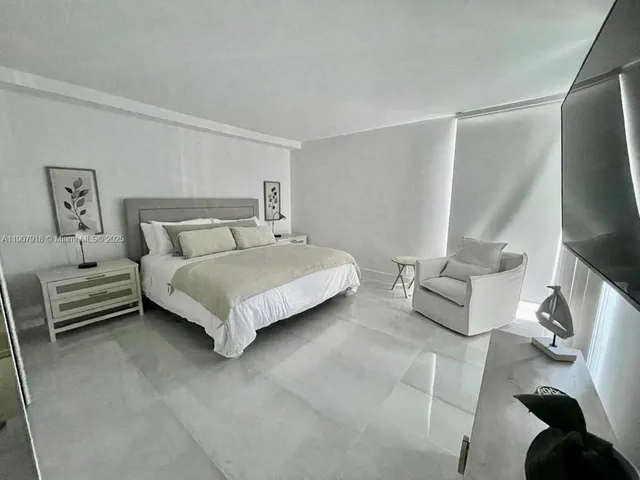 a bedroom with a bed and painting on the wall