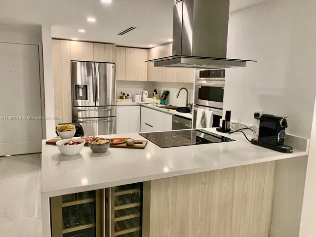 a kitchen with stainless steel appliances a sink stove and refrigerator