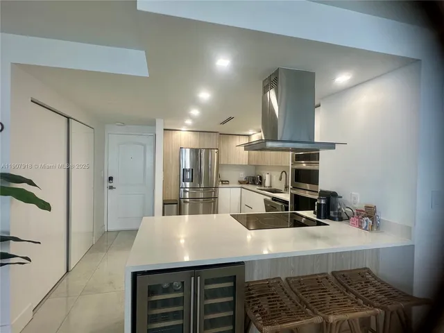 a kitchen with stainless steel appliances a sink stove and refrigerator