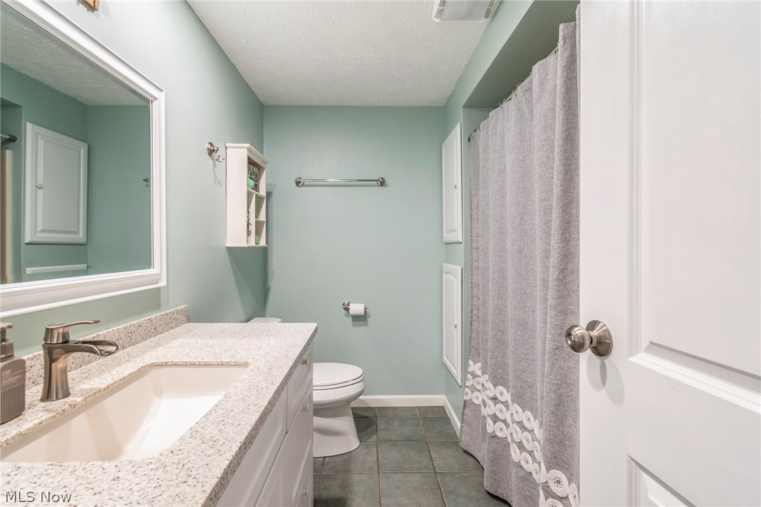 8370 Herbert Road Canfield, OH 44406 - Photo 16 of 48 Bathroom with vanity, toilet, a textured ceiling, and tile floors