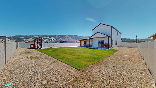 1127 4240 North Enoch, UT 84721 - Photo 53 of 56 Rear view of house featuring a mountain view, a fenced backyard, and a patio