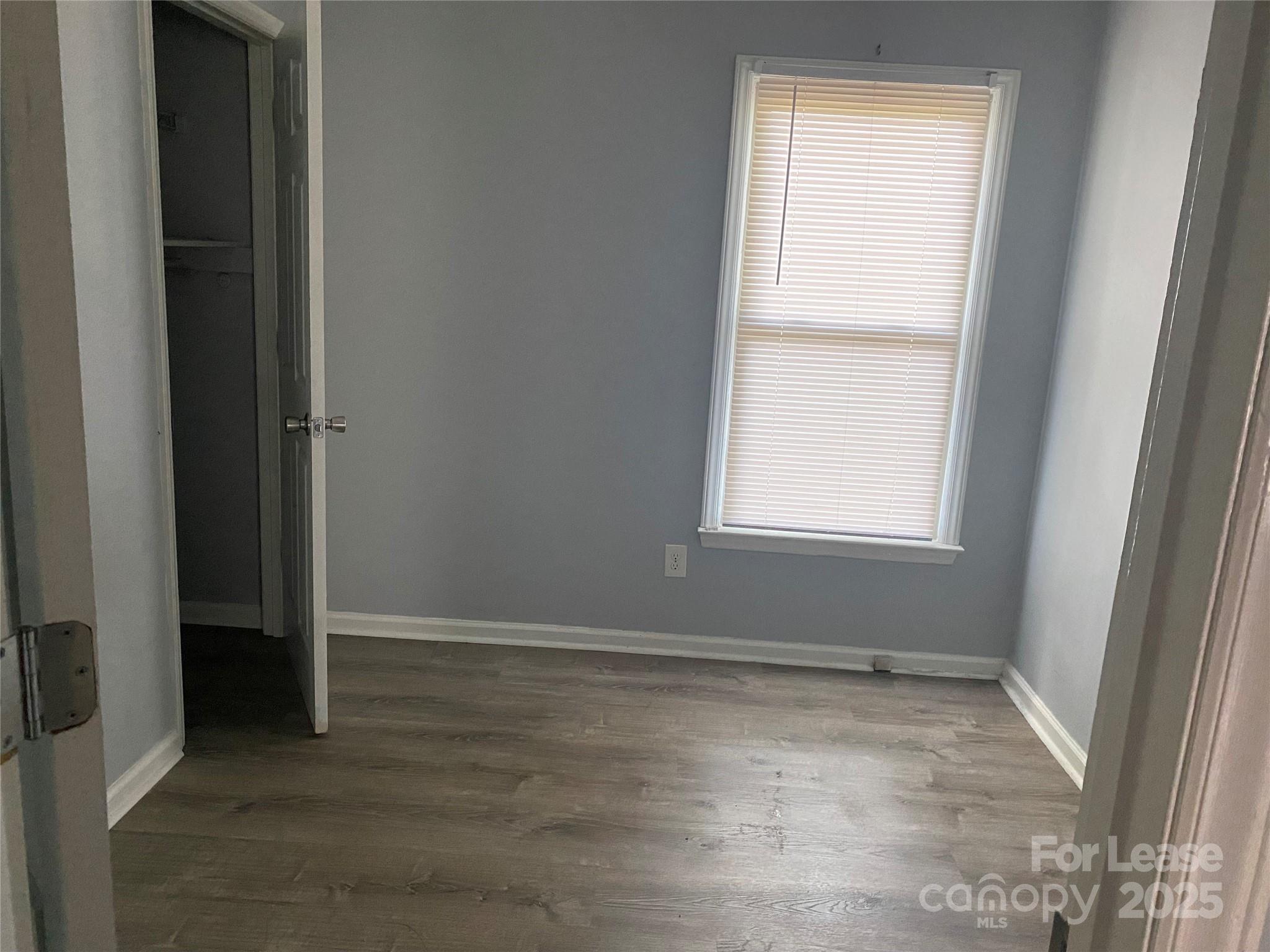 120 West Hudson Street Monroe, NC 28112 - Photo 6 of 9 an empty room with wooden floor and windows