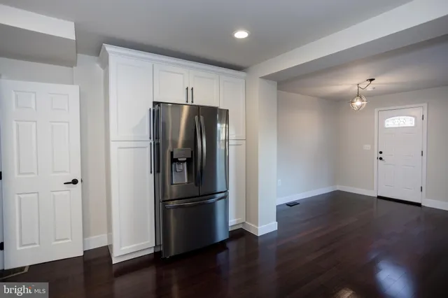 a kitchen with stainless steel appliances wooden floor and a window
