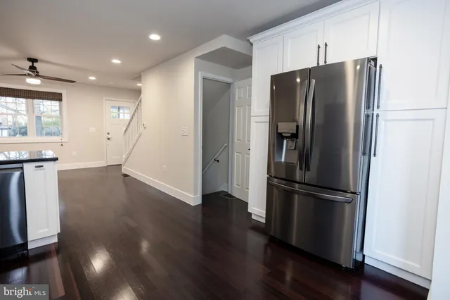 a kitchen with stainless steel appliances a refrigerator and wooden floor