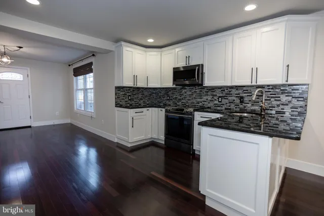 a kitchen with granite countertop a sink and a stove top oven