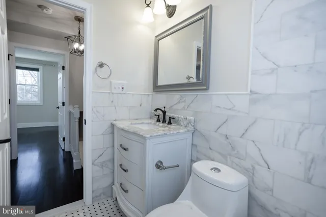 a bathroom with a granite countertop toilet sink and mirror