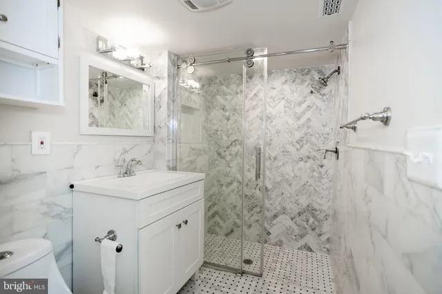 a bathroom with a sink mirror and shower