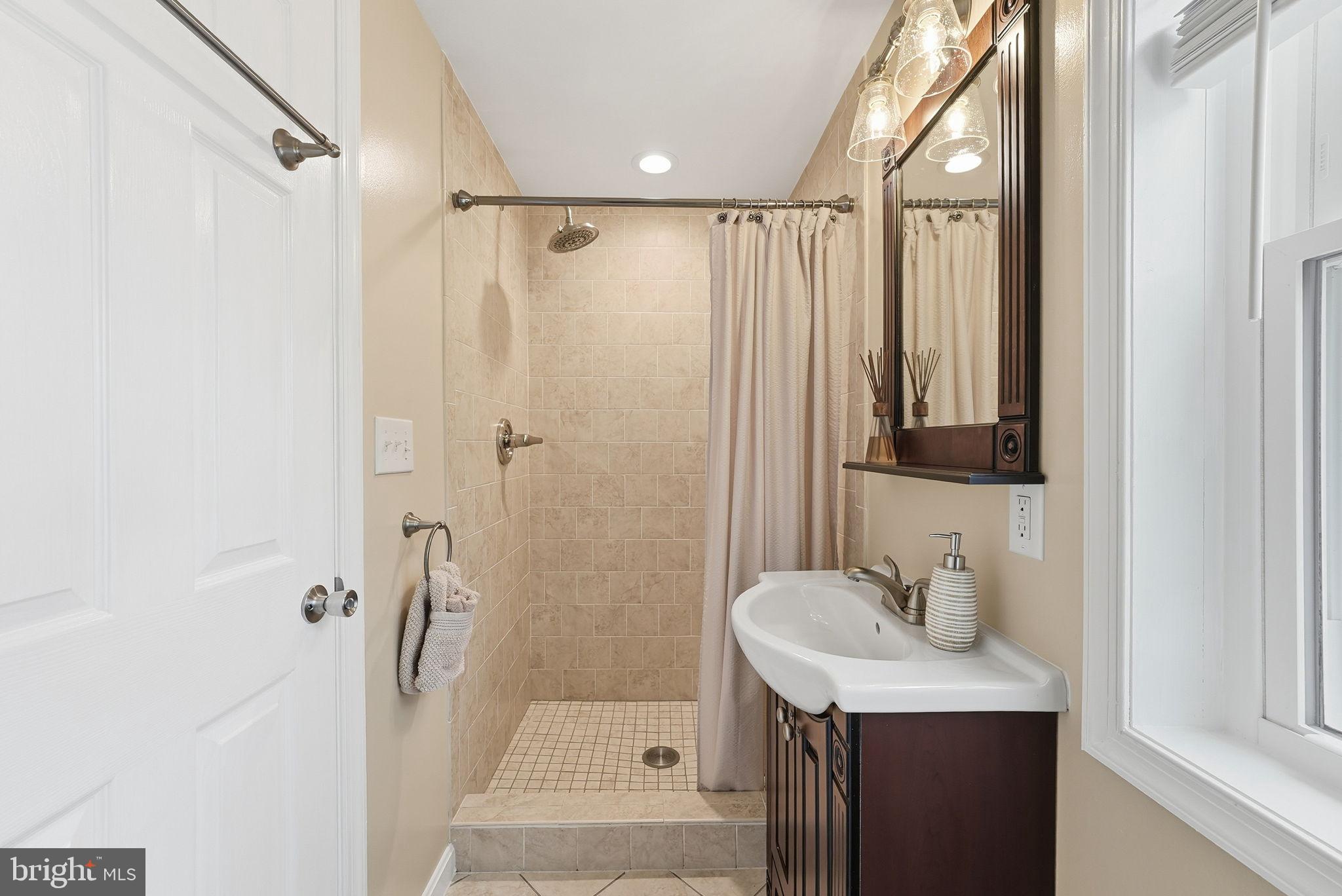 6803 Derrell Court Alexandria, VA 22307 - Photo 28 of 43 a bathroom with a sink a mirror a vanity and a shower