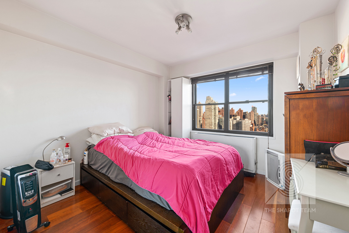 345 East 80th Street, Unit 30K Manhattan, NY 10075 - Photo 6 of 12 a bed sitting in a bedroom next to a window