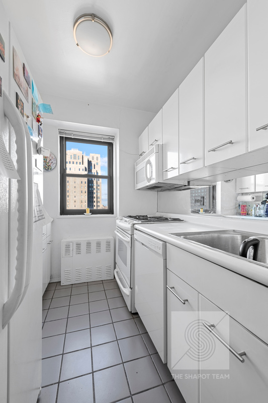345 East 80th Street, Unit 30K Manhattan, NY 10075 - Photo 10 of 12 a kitchen with white cabinets appliances and a window