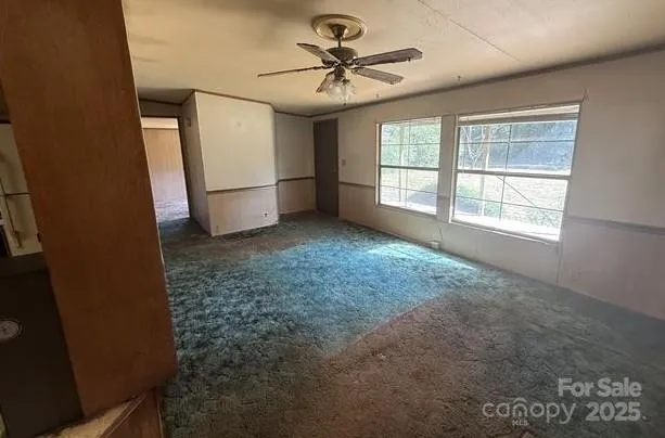 a view of a livingroom with a ceiling fan and window