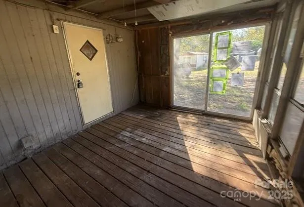 a view of a room with wooden floor and a window