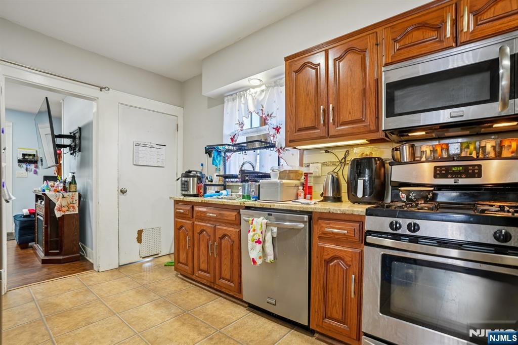 228 Totowa Road Totowa, NJ 07512 - Photo 13 of 39 a kitchen with stainless steel appliances granite countertop a stove a sink and a microwave