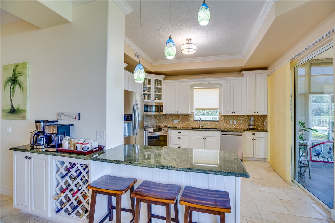 1701 Gulfstream Avenue, Unit 719 Fort Pierce, FL 34949 - Photo 14 of 36 a kitchen with granite countertop sink cabinets and stainless steel appliances