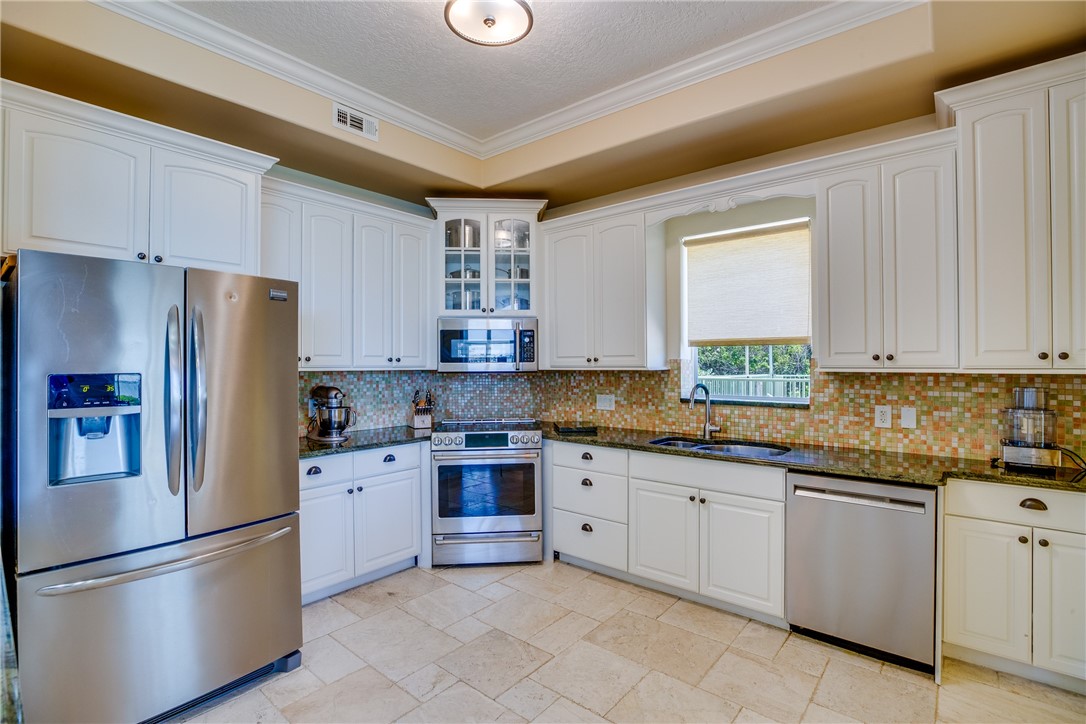1701 Gulfstream Avenue, Unit 719 Fort Pierce, FL 34949 - Photo 15 of 36 a kitchen with granite countertop stainless steel appliances and white cabinets