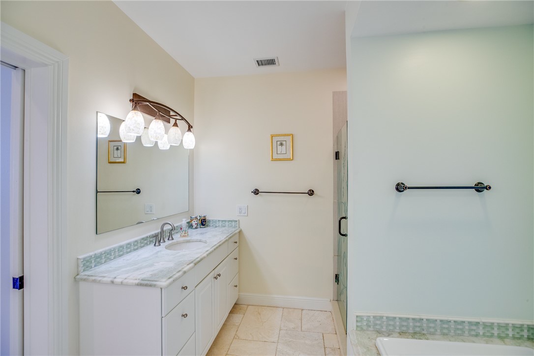 1701 Gulfstream Avenue, Unit 719 Fort Pierce, FL 34949 - Photo 18 of 36 a bathroom with a granite countertop sink a mirror and a shower