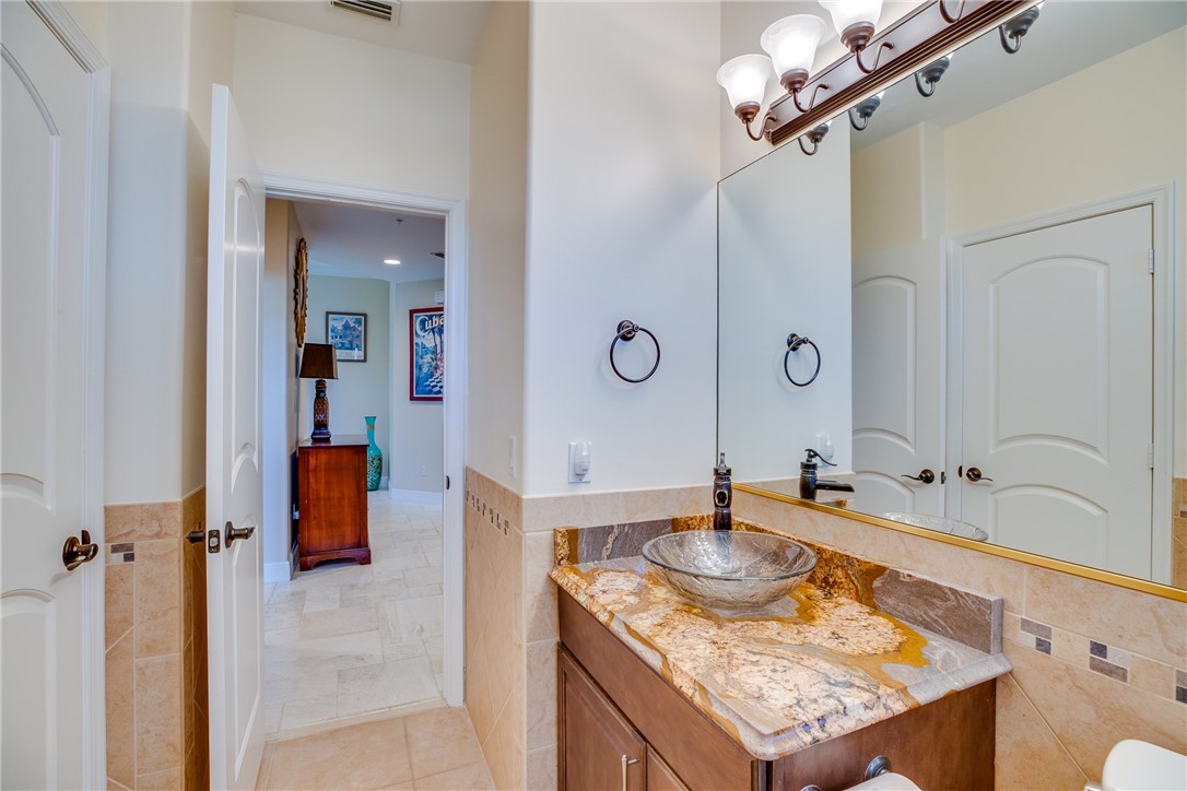 1701 Gulfstream Avenue, Unit 719 Fort Pierce, FL 34949 - Photo 22 of 36 a bathroom with a granite countertop sink a mirror and shower