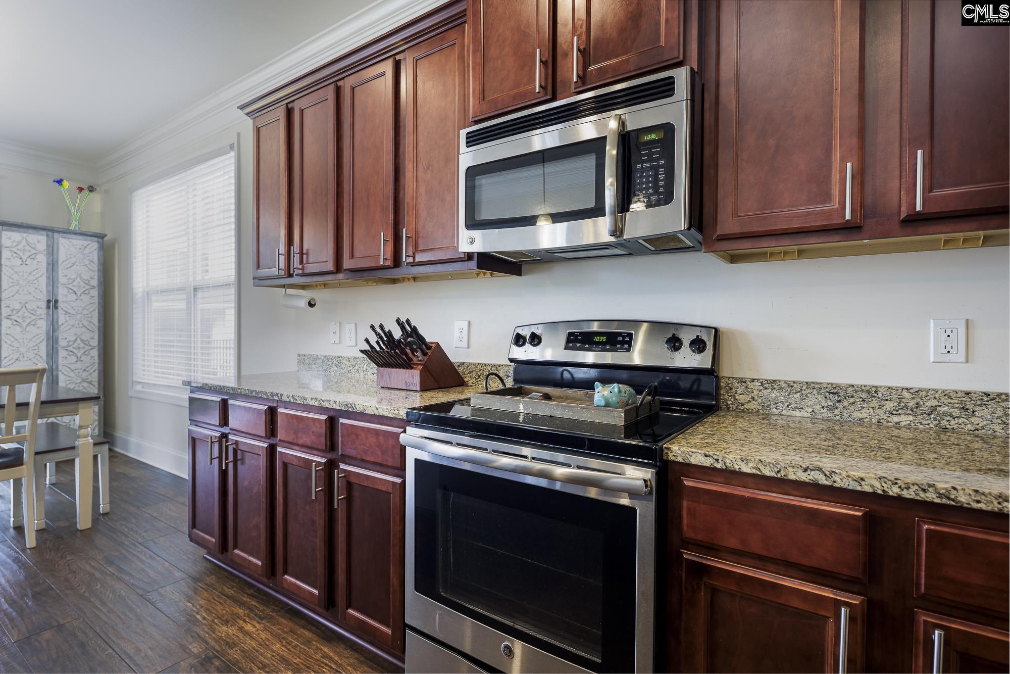 213 Sunset Point Drive Lexington, SC 29072 - Photo 12 of 35 a kitchen with stainless steel appliances granite countertop wooden cabinets and a stove top oven
