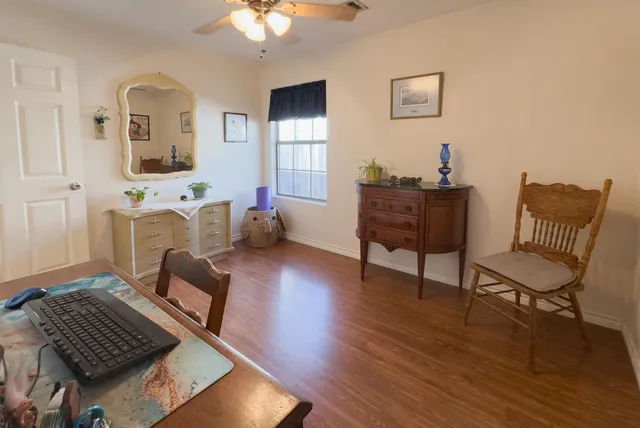 a view of a workspace with furniture and a window