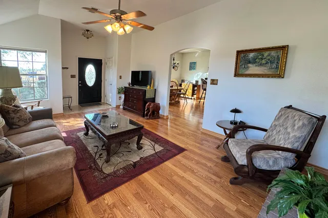 a living room with furniture a chandelier and a table