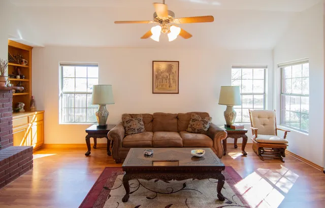 a living room with furniture wooden floor and a window