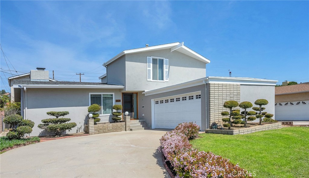 a front view of a house with a garden and a patio
