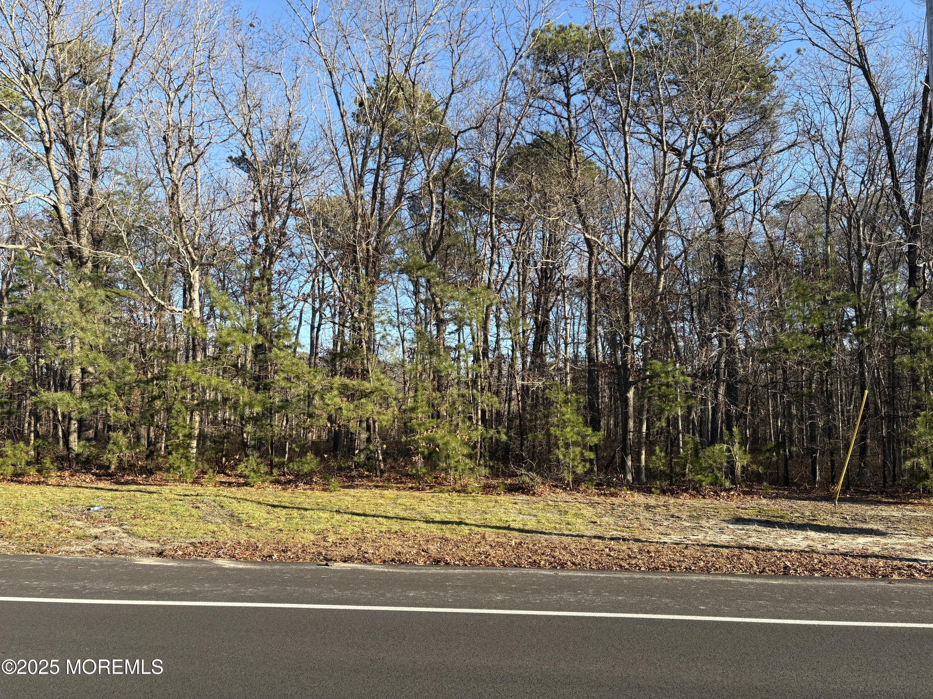 a view of a house with a yard and large trees