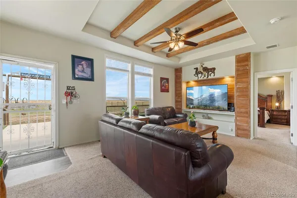 a living room with furniture kitchen view and a chandelier