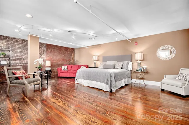 a spacious bedroom with a bed a couch and a large window