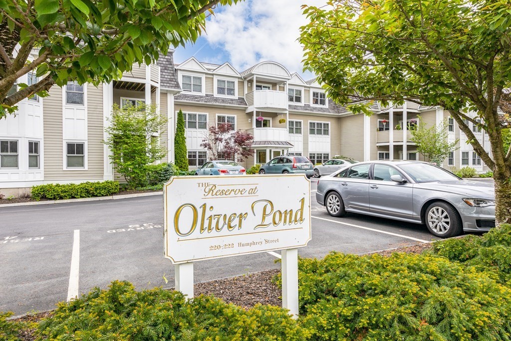 a view of a white house with large windows and a yard