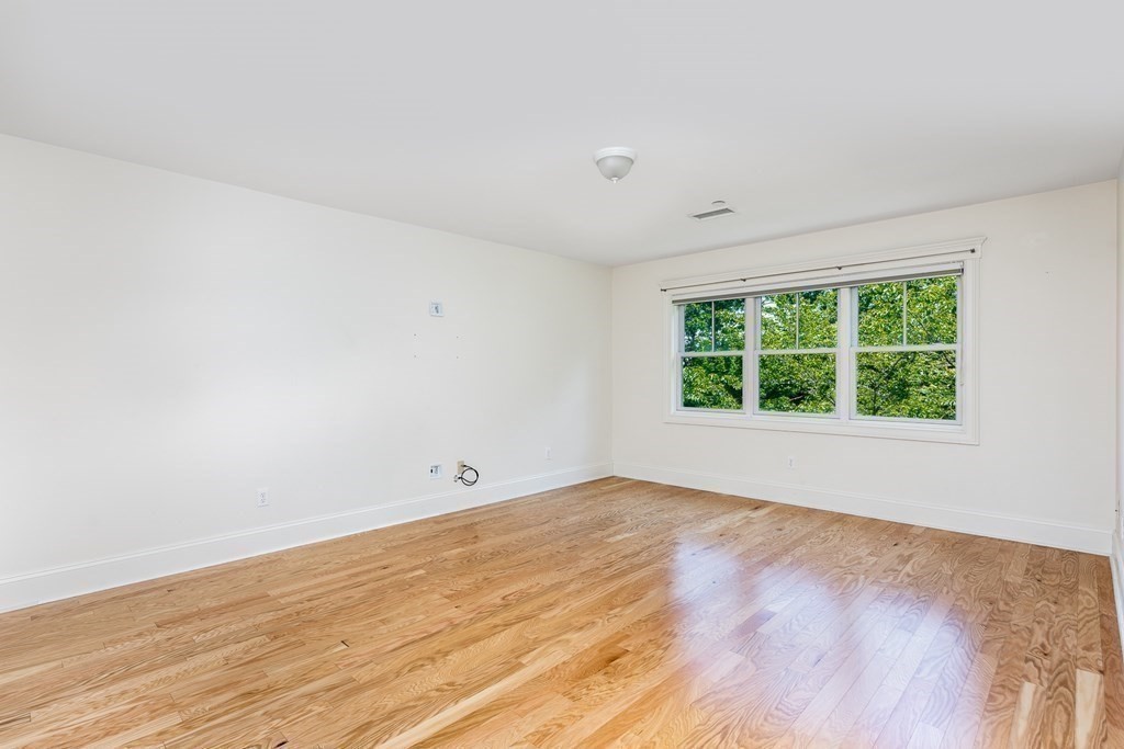 220 Humphrey Street, Unit 204 Marblehead, MA 01945 - Photo 15 of 29 a view of an empty room with wooden floor and a window