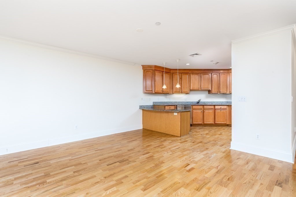 220 Humphrey Street, Unit 204 Marblehead, MA 01945 - Photo 9 of 29 a kitchen with granite countertop a stove and a wooden floors