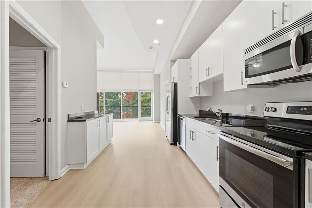 a large kitchen with stainless steel appliances granite countertop a stove and a refrigerator