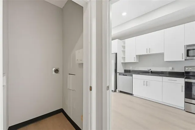 a kitchen with granite countertop white cabinets and white appliances