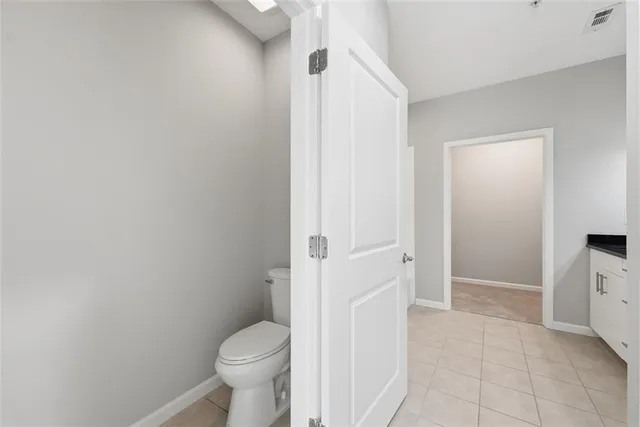a bathroom with a granite countertop toilet and a sink