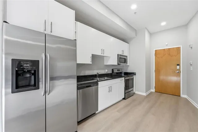 a kitchen with stainless steel appliances granite countertop a refrigerator and a stove