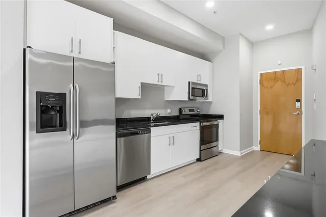 a kitchen with stainless steel appliances a refrigerator and a stove top oven