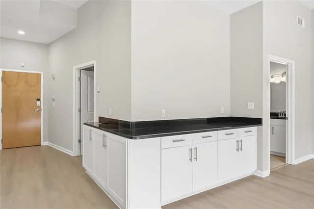 a kitchen with granite countertop white cabinets and white appliances