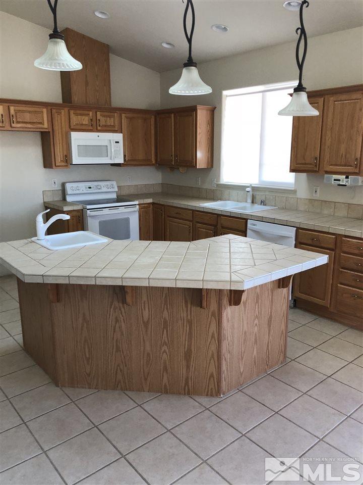 11000 Osage Road Reno, NV 89508 - Photo 11 of 20 a kitchen with kitchen island granite countertop a sink counter top space cabinets and stainless steel appliances