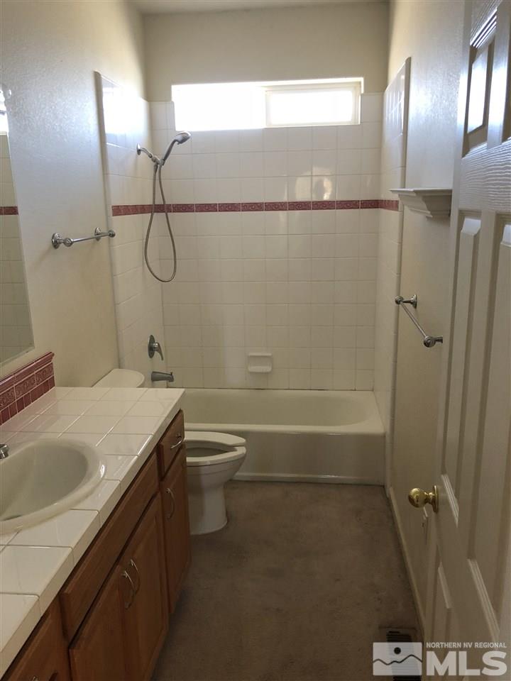 11000 Osage Road Reno, NV 89508 - Photo 5 of 20 a bathroom with a granite countertop sink a toilet and shower