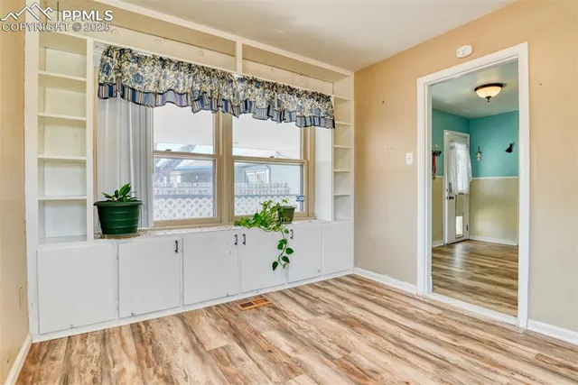 a view of a bedroom with wooden floor and windows