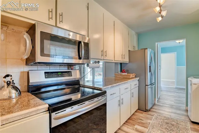 a kitchen with stainless steel appliances kitchen island granite countertop a refrigerator and a stove top oven