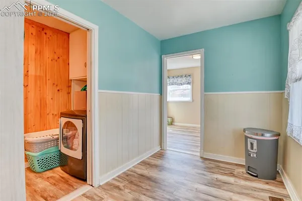 a view of a storage and utility room with wooden floor